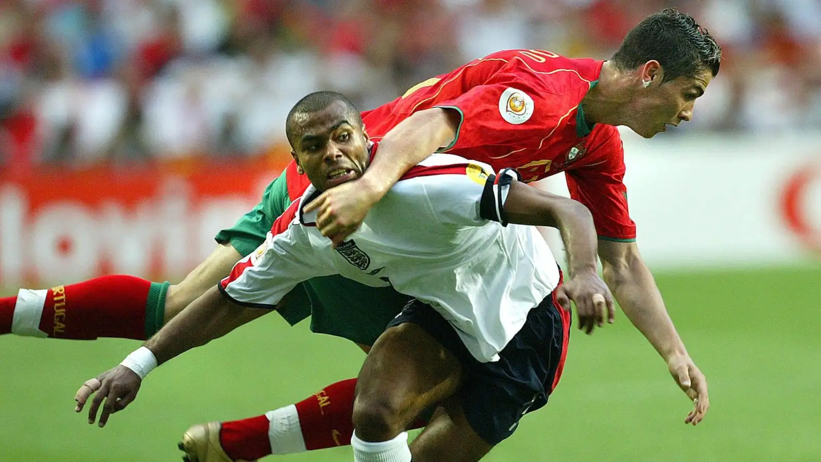 England's Ashley Cole, front, tussles with Portugal's Cristiano Ronaldo during the Euro 2004 quarter final soccer match between England and Portugal at the Luz Stadium in Lisbon, Portugal, Thursday June 24, 2004.