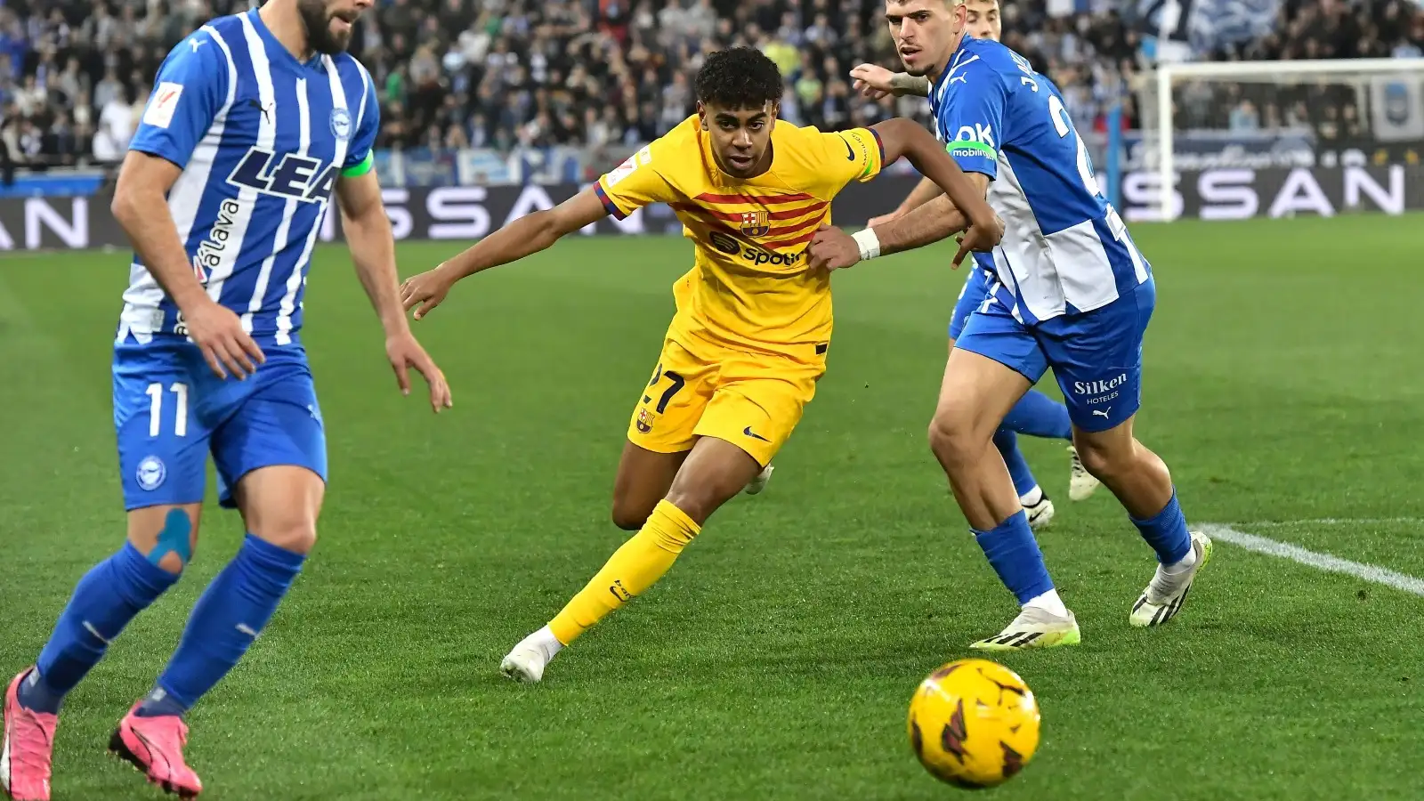 Barcelona's Lamine Yamal, centre, challenges for the ball with Alaves' Luis Rioja, left, and Alaves' Javi Lopez during the La Liga soccer match between Deportivo Alaves and FC Barcelona at the Medizorrosa stadium in Vitoria, Spain, Saturday, Feb. 3, 2024.